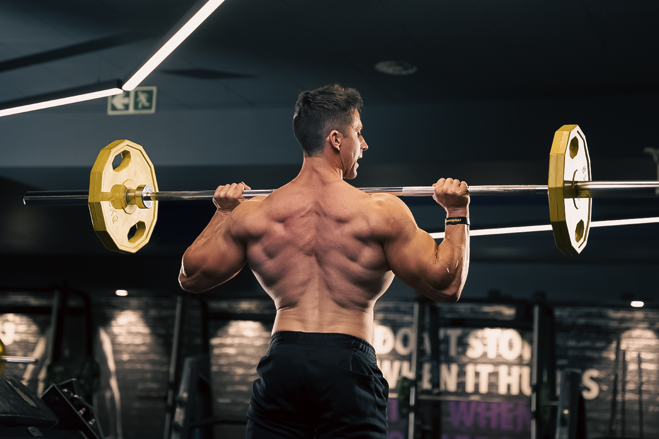 rear shot of NPL athlete performing a shoulder press, blog post discusses what a body recomp is and why its important