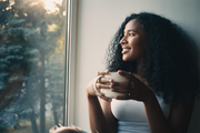 Model holding a cup in her hands, blog post is discusses the benefits and uses for green tea