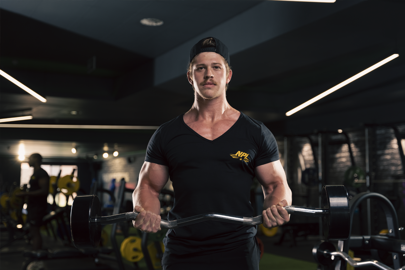 NPL athlete performing a bicep curl, blog states the importance of building and understanding the mind muscle connection